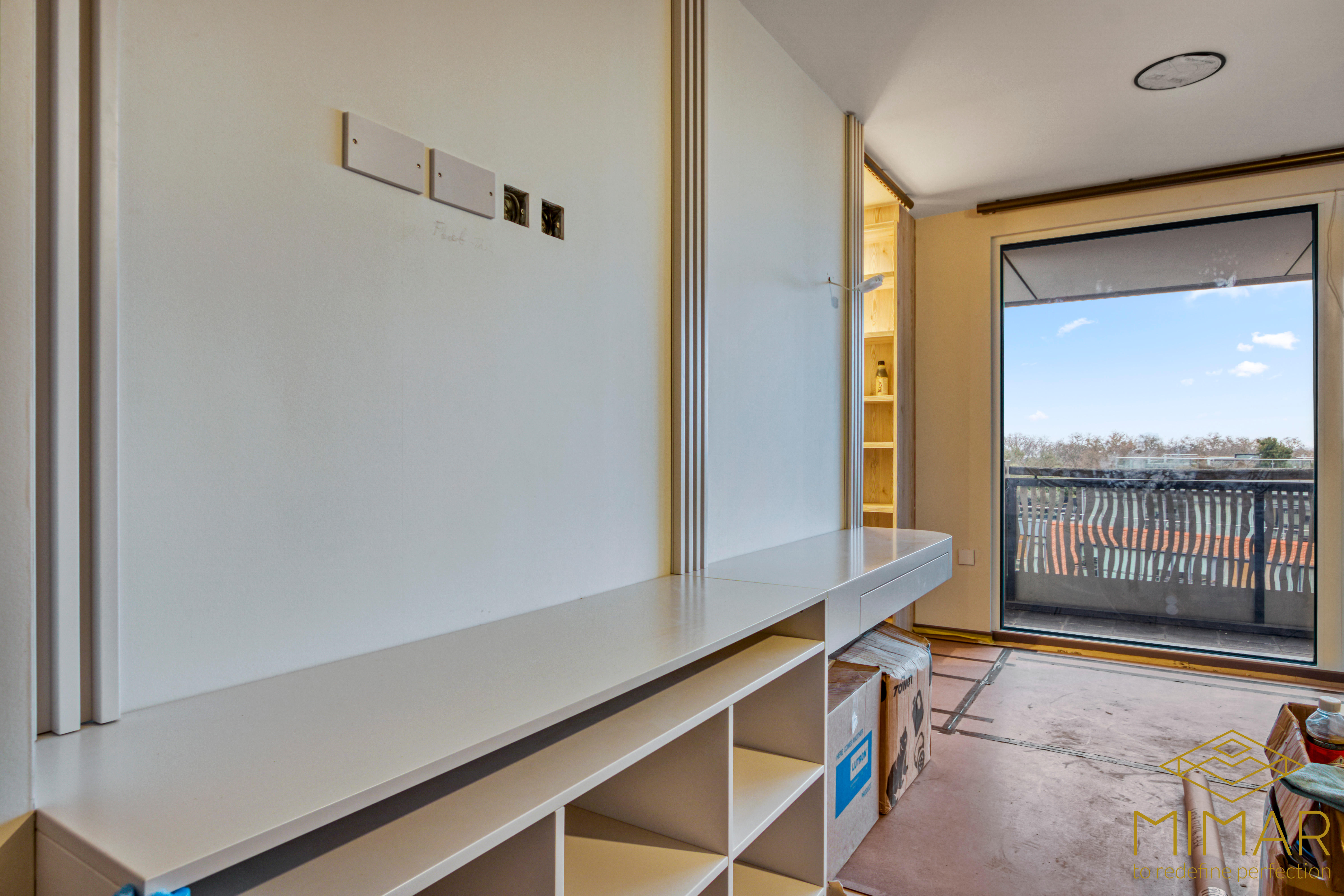 Interior view of a loft conversion featuring built-in shelving units and a sliding door leading to a balcony.