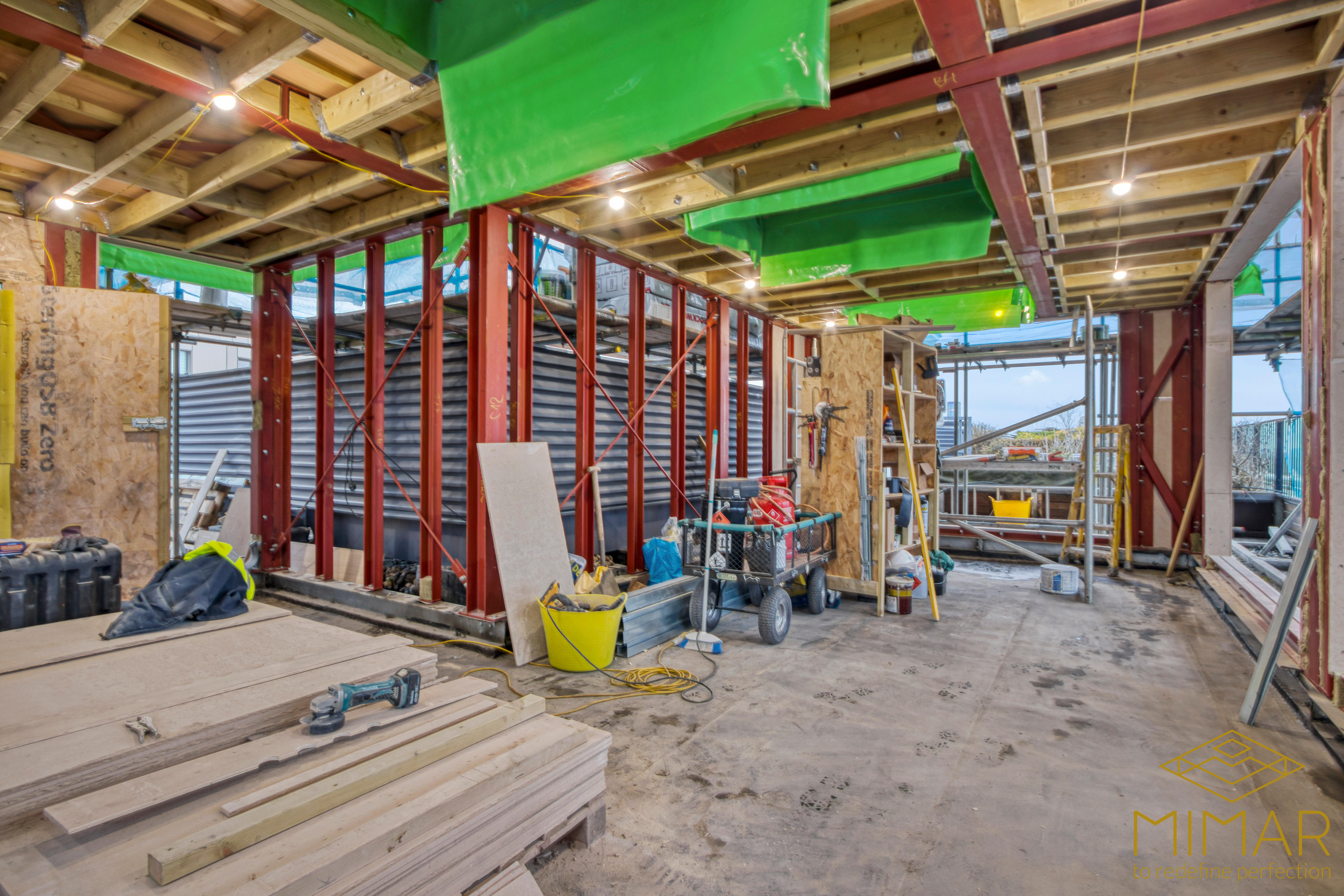 Interior view of a loft extension under construction with exposed wooden beams and steel supports.