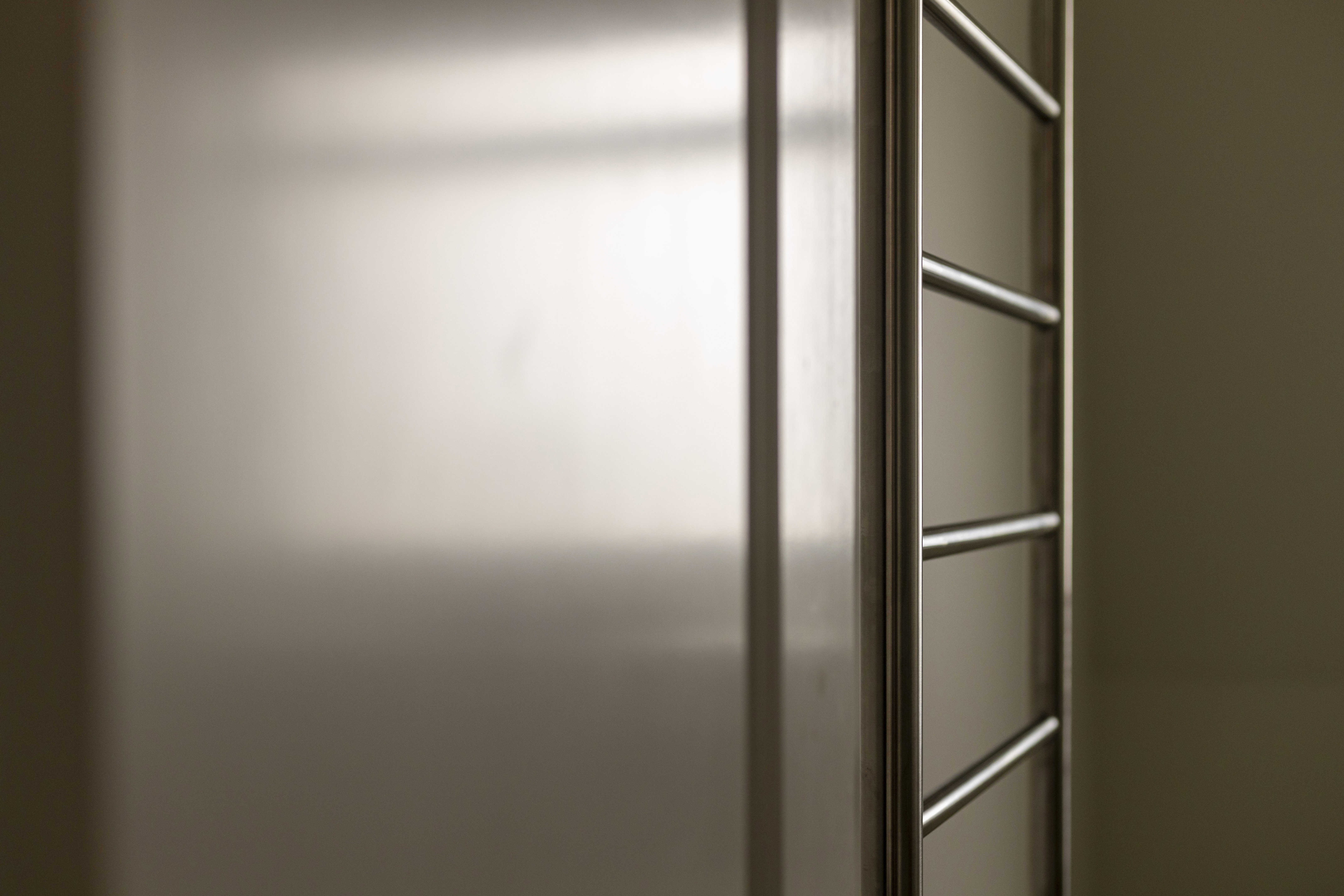 Close-up image of a stainless steel railing or fixture, highlighting vertical and horizontal bars.